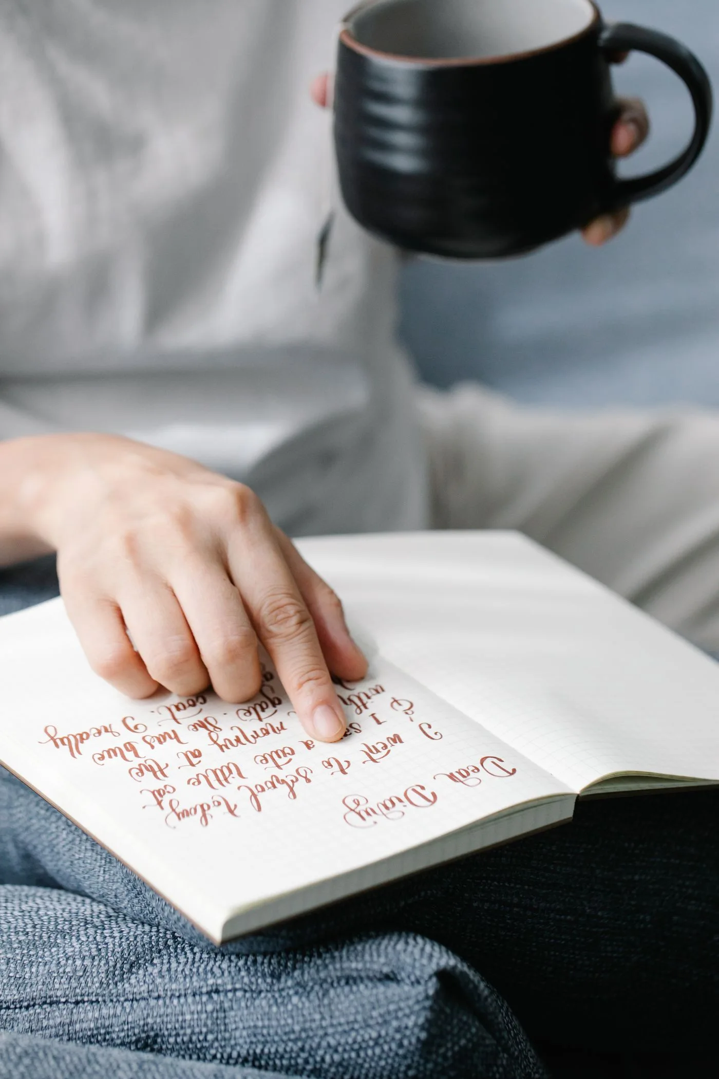A hand following handwritten notes in an open journal